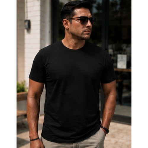 A man wearing a plain black short-sleeve crewneck t-shirt and beige pants, standing outdoors in front of a building with a glass storefront.