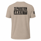 A light tan short-sleeve t-shirt shown from the back, featuring the words 'SEPARATION ANXIETY' printed in a distressed black block font across the upper back. A small black American flag graphic is printed on the left sleeve.