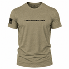 A heathered khaki short-sleeve t-shirt with 'LEAD WITHOUT FEAR' printed in black across the chest and a black American flag graphic on the right sleeve, shown on a plain white background.