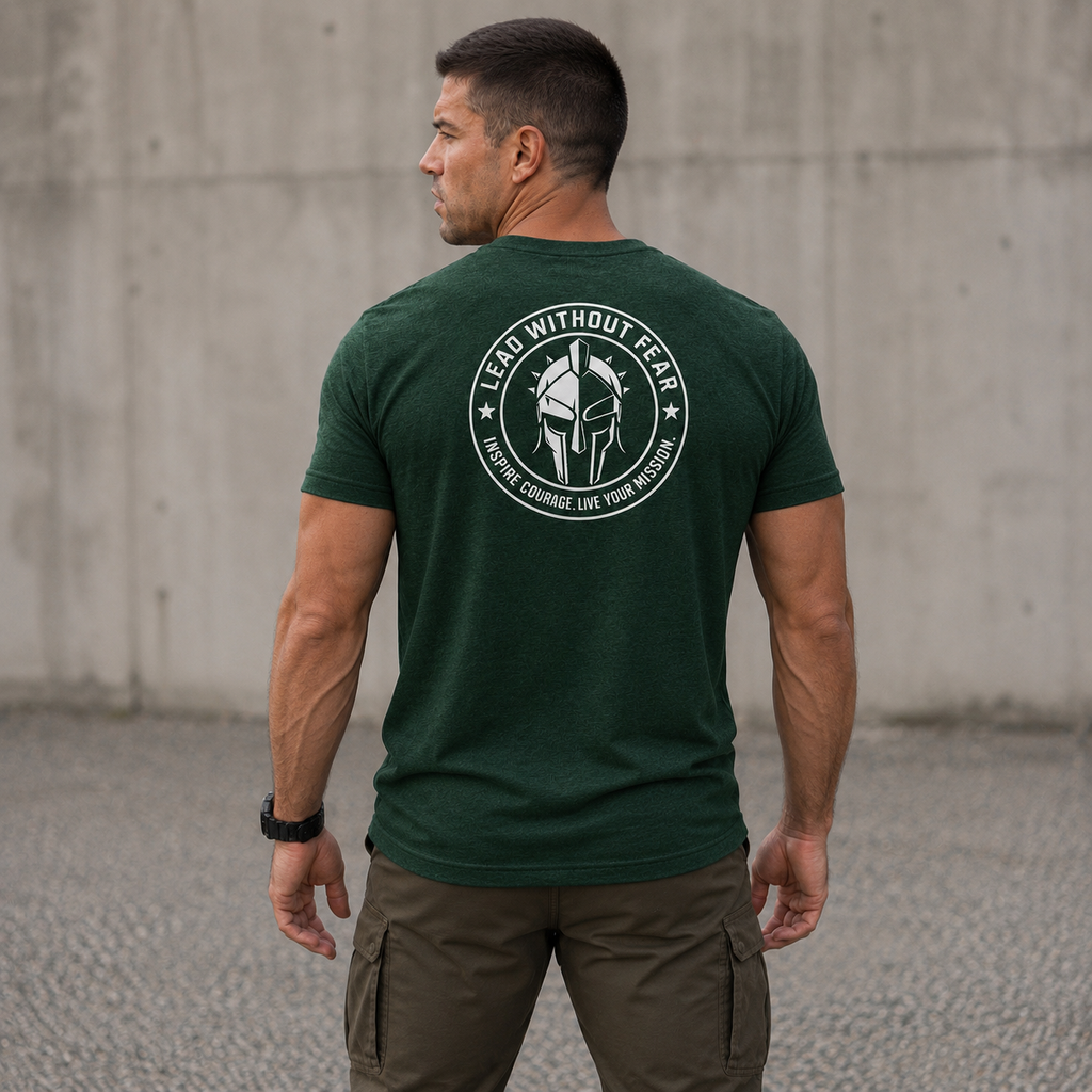 A man viewed from behind wearing a dark green t-shirt with a white circular graphic on the back featuring a gladiator helmet and the text 'LEAD WITHOUT FEAR'.