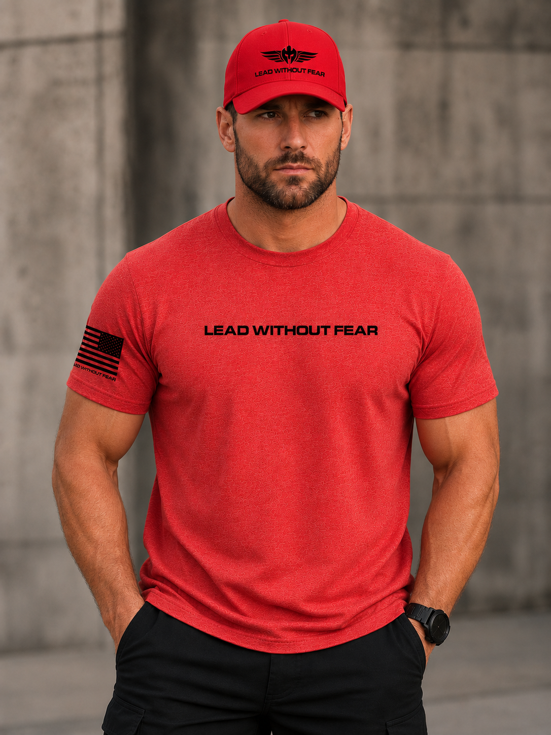 A man wearing a red crewneck t-shirt with 'LEAD WITHOUT FEAR' printed across the chest and a black American flag graphic on the sleeve, paired with a matching red baseball cap.