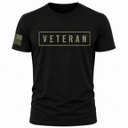 A black short-sleeve crewneck t-shirt featuring a military green rectangular graphic on the chest with the word 'VETERAN' inside, and a tan American flag graphic on the right sleeve.