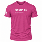 A Berry pink short-sleeve t-shirt with 'STAND BY' printed in distressed white letters on the chest, and a distressed white American flag graphic on the right sleeve.