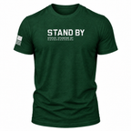 A dark green heathered short-sleeve t-shirt with 'STAND BY' and 'STATUS: STANDING BY' printed in distressed white text on the chest, featuring a black-and-white American flag graphic on the right sleeve, shown on a plain white background.