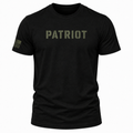 A black short-sleeve crewneck t-shirt featuring the word 'PATRIOT' printed in distressed olive green letters across the chest, with a small olive green American flag graphic on the right sleeve, shown against a plain white background.