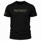 A black short-sleeve crewneck t-shirt featuring the word 'PATRIOT' printed in distressed olive green letters across the chest, with a small olive green American flag graphic on the right sleeve, shown against a plain white background.
