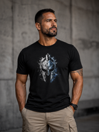 A man wearing a black short-sleeve t-shirt with a metallic Spartan helmet graphic on the chest, paired with khaki cargo pants, standing against a gray concrete wall.